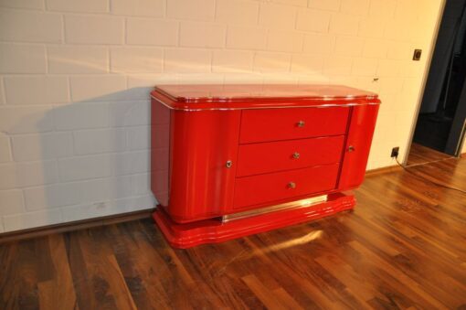 Art Deco Lowboard, red highgloss paintjob, wonderful swing doors, 3 drawers with chromehandles, chromeapplications on the foot