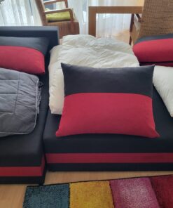 Schwarz rote Schalfcouch mit Bettwäsche